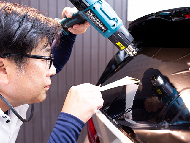 ウィンドウフィルムを車外から作業する様子